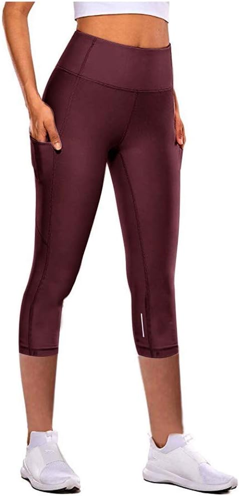 Donna incinta che indossa leggings premaman in cotone vita alta Free People durante una sessione di yoga leggero in salotto